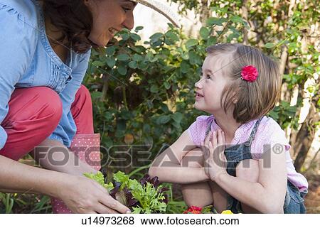 Stock Photo - Mother and daughter gardening together. Fotosearch