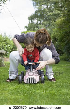 Stock Image - Mother and daughter playing in backyard. Fotosearch