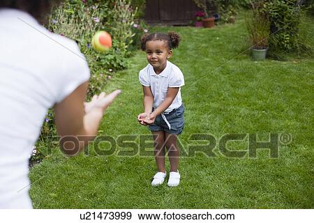 Stock Photo - Mother and daughter playing in garden. Fotosearch