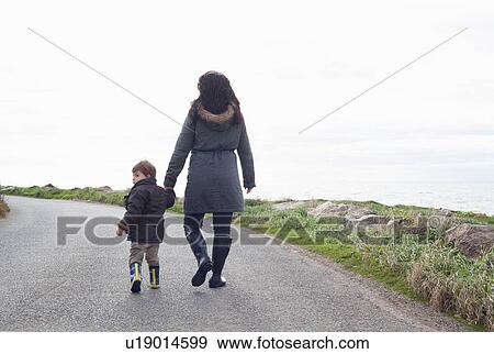 Mother and son walking on rural road View Large Photo Image Stock Photo - Mother and son walking on rural road. Fotosearch