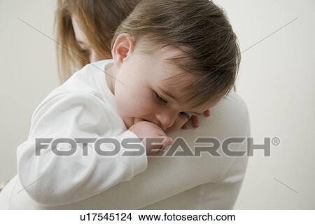 Mother holding daughter indoors View Large Photo Image Picture - Mother holding daughter indoors. Fotosearch