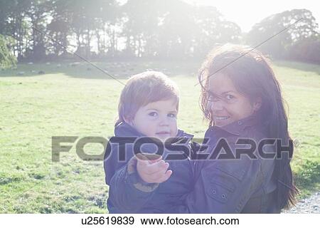 Mother holding son outdoors View Large Photo Image Stock Photo - Mother holding son outdoors. Fotosearch