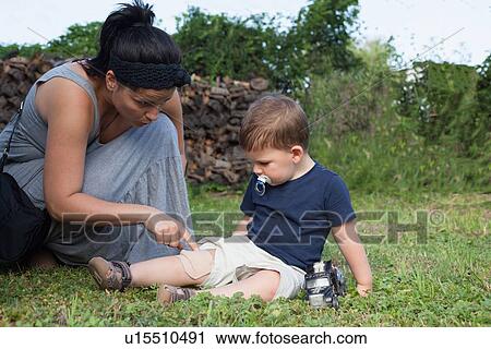 Mother putting bandage on boys knee View Large Photo Image Stock Image - Mother putting bandage on boys knee. Fotosearch