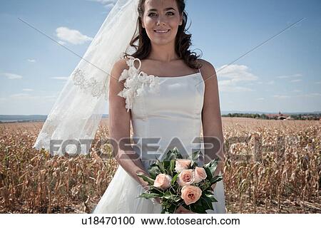 Stock Image - Newlywed bride holding bouquet. Fotosearch
