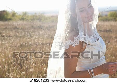 Newlywed bride standing outdoors View Large Photo Image Stock Image - Newlywed bride standing outdoors. Fotosearch