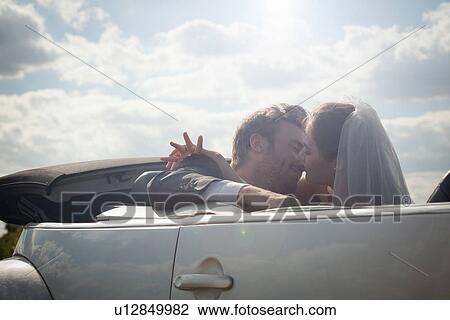 Newlywed couple about to kiss in a convertible View Large Photo Image Stock Image - Newlywed couple about to kiss in a convertible. Fotosearch