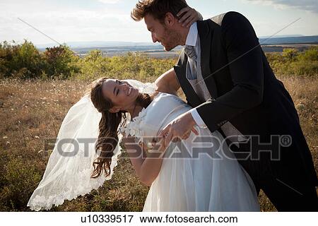 Stock Photo - Newlywed couple dancing outdoors. Fotosearch