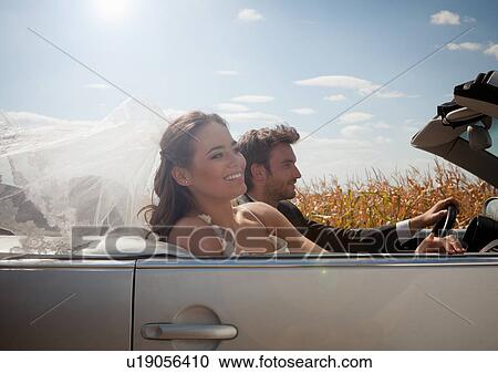 Newlywed couple driving in convertible View Large Photo Image Stock Image - Newlywed couple driving in convertible. Fotosearch