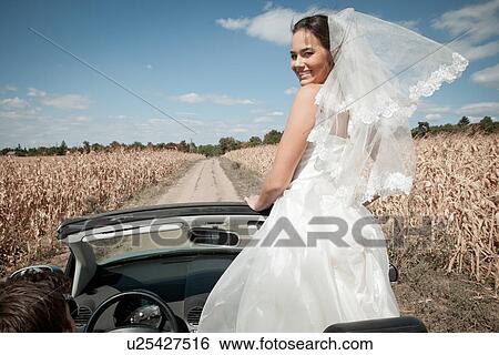 Newlywed couple driving in convertible View Large Photo Image Stock Photograph - Newlywed couple driving in convertible. Fotosearch
