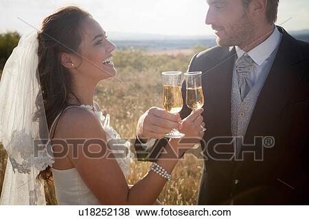 Newlywed couple having champagne View Large Photo Image Stock Photo - Newlywed couple having champagne. Fotosearch