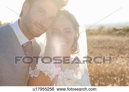 Stock Photograph - Newlywed couple hugging outdoors. Fotosearch
