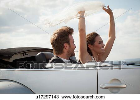 Newlywed couple riding in convertible View Large Photo Image Stock Image - Newlywed couple riding in convertible. Fotosearch