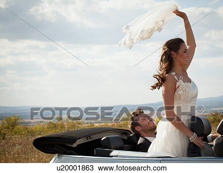 Newlywed couple riding in convertible View Large Photo Image Stock Image - Newlywed couple riding in convertible. Fotosearch