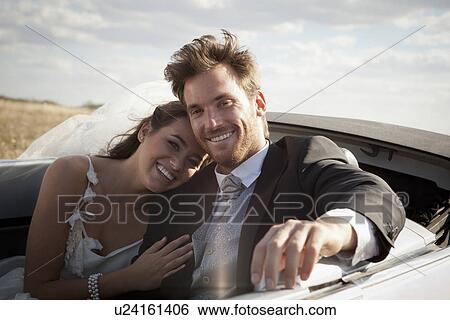 Newlywed couple riding in convertible View Large Photo Image Stock Photograph - Newlywed couple riding in convertible. Fotosearch