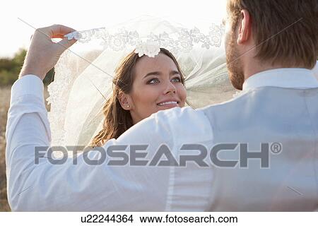 Picture - Newlywed couple standing outdoors. Fotosearch
