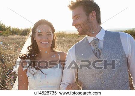 Stock Photography - Newlywed couple walking in confetti. Fotosearch