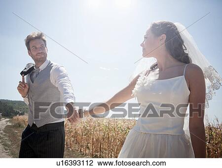 Stock Image - Newlywed couple walking outdoors. Fotosearch