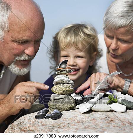 Stock Image - Older couple and granddaughter outdoors. Fotosearch