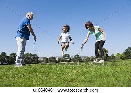 Stock Image - Older couple playing with granddaughter. Fotosearch