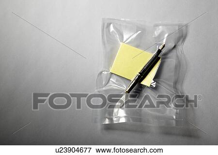 Stock Photo - Pen and paper shrink wrapped in plastic. Fotosearch