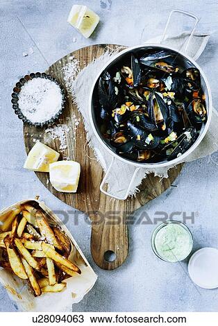 Stock Image - Platter of steamed mussels and fries. Fotosearch