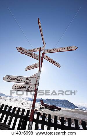 Stock Photo - Post with road signs by wooden fence. Fotosearch