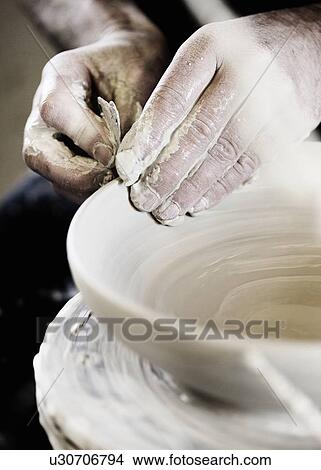 Picture - Potter creating handcrafted bowl in shop. Fotosearch