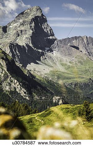 Rocky mountains over grassy landscape View Large Photo Image Stock Photo - Rocky mountains over grassy landscape. Fotosearch