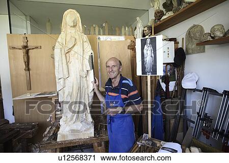 Sculptor standing with wood figure View Large Photo Image Stock Image - Sculptor standing with wood figure. Fotosearch