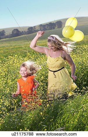Sisters playing in field of flowers View Large Photo Image Stock Photo - Sisters playing in field of flowers. Fotosearch