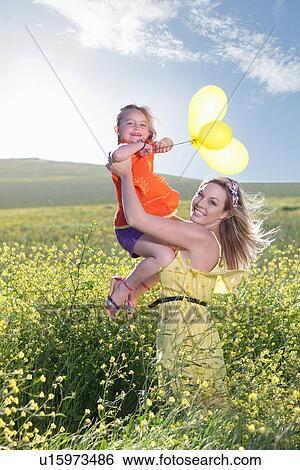 Sisters playing in field of flowers View Large Photo Image Stock Photograph - Sisters playing in field of flowers. Fotosearch