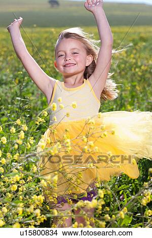 Smiling girl playing in field of flowers View Large Photo Image Picture - Smiling girl playing in field of flowers. Fotosearch