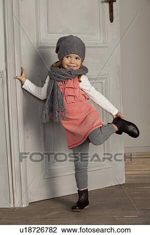 Stock Image - Smiling girl wearing hat and scarf. Fotosearch