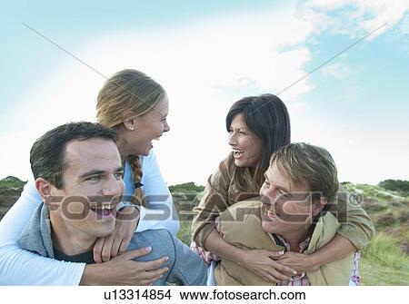 Smiling men carrying women outdoors View Large Photo Image Picture - Smiling men carrying women outdoors. Fotosearch