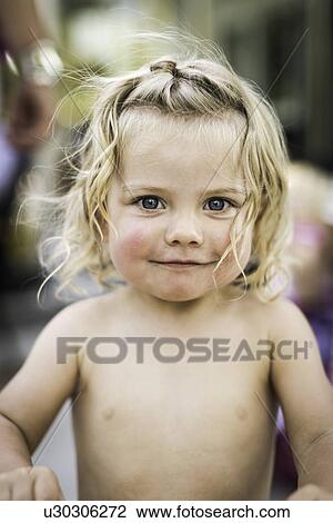 Stock Image - Smiling toddler girl standing outdoors. Fotosearch