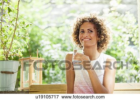 Smiling woman drinking glass of water View Large Photo Image Stock Photo - Smiling woman drinking glass of water. Fotosearch