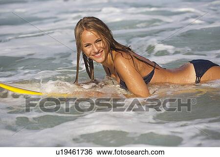 Smiling woman on surfboard in waves View Large Photo Image Stock Photograph - Smiling woman on surfboard in waves. Fotosearch