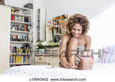 Smiling woman polishing toenails View Large Photo Image Stock Image - Smiling woman polishing toenails. Fotosearch