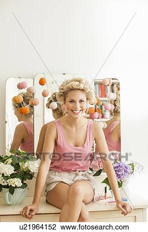 Smiling woman sitting on vanity View Large Photo Image Stock Image - Smiling woman sitting on vanity. Fotosearch