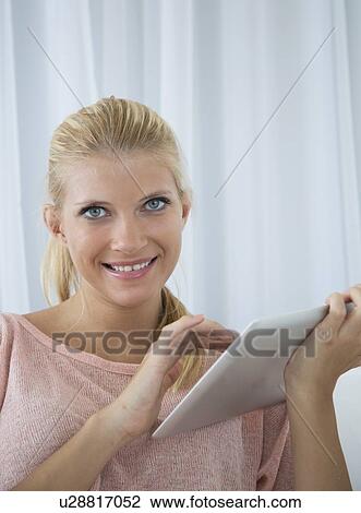 Smiling woman using tablet computer View Large Photo Image Stock Image - Smiling woman using tablet computer. Fotosearch