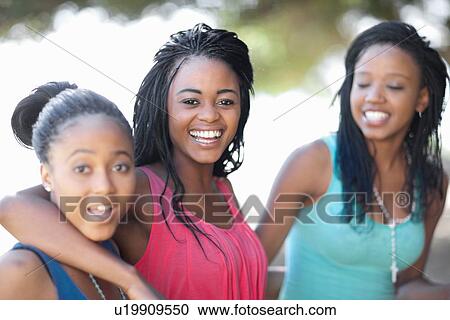 Smiling women hugging outdoors View Large Photo Image Stock Image - Smiling women hugging outdoors. Fotosearch