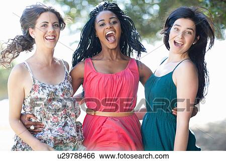 Smiling women hugging outdoors View Large Photo Image Stock Photograph - Smiling women hugging outdoors. Fotosearch