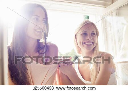 Smiling women sitting in windowsill View Large Photo Image Stock Image - Smiling women sitting in windowsill. Fotosearch