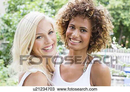 Smiling women standing together View Large Photo Image Stock Image - Smiling women standing together. Fotosearch