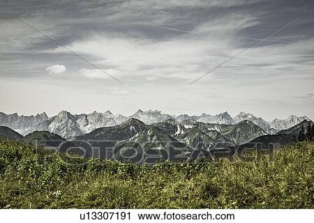 Snowy mountains and grassy fields View Large Photo Image Stock Image - Snowy mountains and grassy fields. Fotosearch