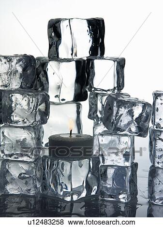 Stock Photo - Stacks of ice cubes and candle. Fotosearch