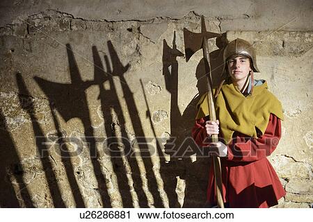 Stock Image - Student examining medieval weapons. Fotosearch