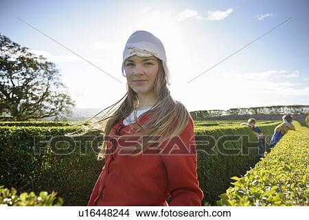 Picture - Student in period dress in hedge maze. Fotosearch