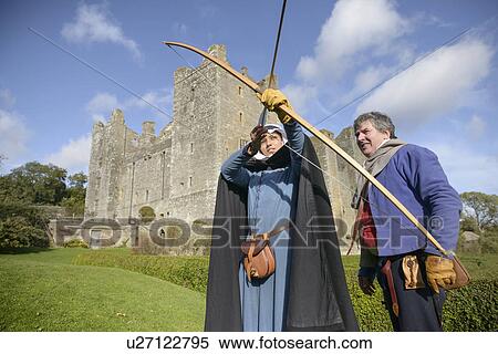 Stock Photography - Student in period dress shooting arrow. Fotosearch