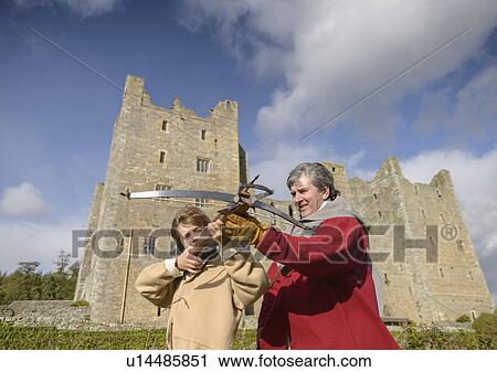 Stock Image - Student in period dress with crossbow. Fotosearch